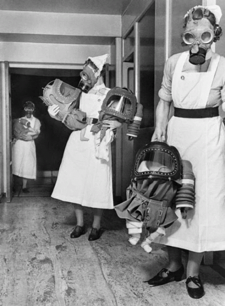 Медсестры держат младенцев, «одетых» в противогазы, предназначенные специально для детей до двух лет, 1940 год, Лондон